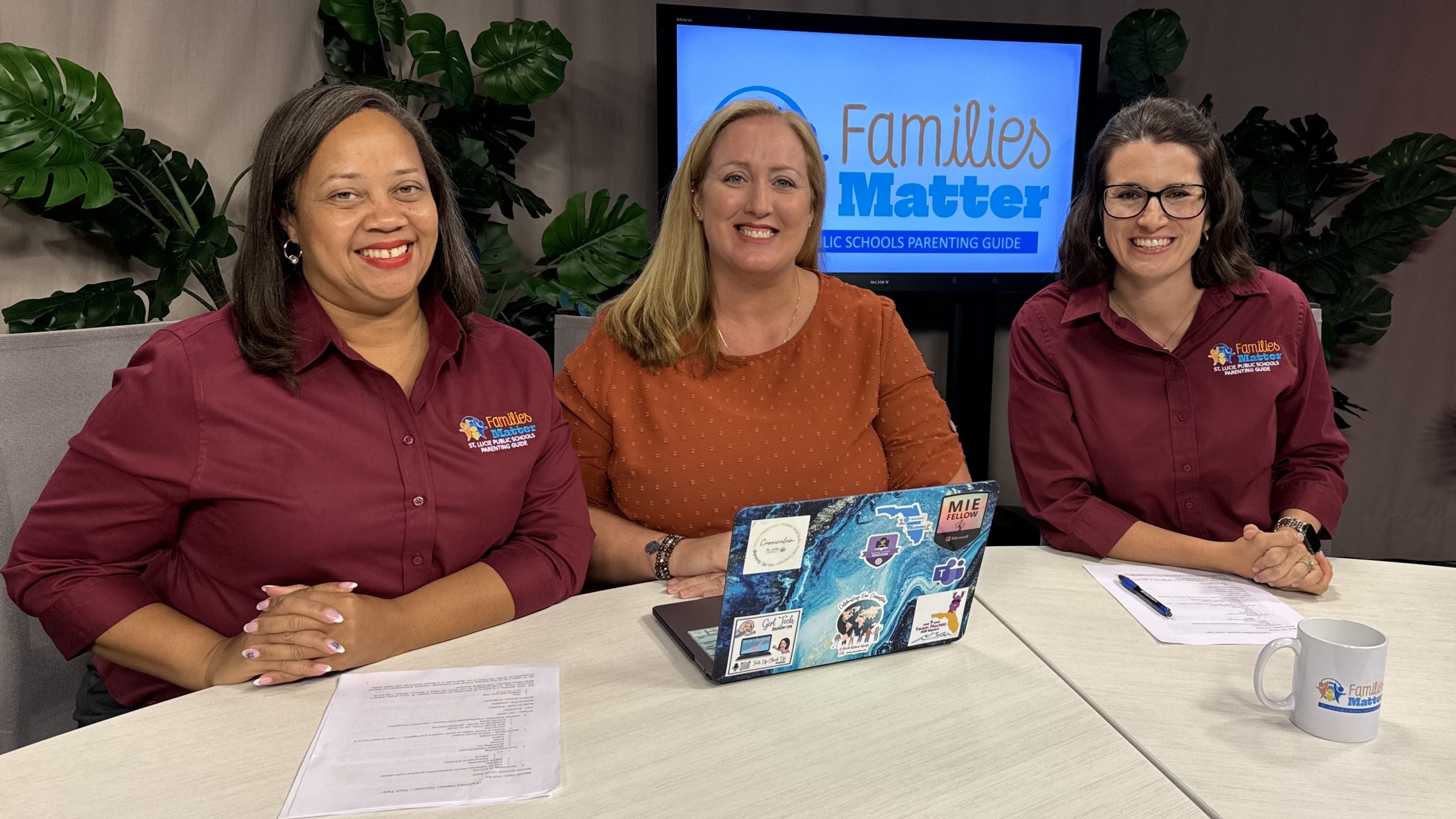 Three women at a table with "Families Matter" logo, laptop, and papers.
